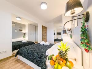 Habitación de hotel con 2 camas y una mesa con fruta. en Beskid Apartamenty en Nowy Sącz