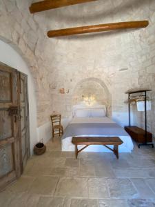 een slaapkamer met een bed in een stenen muur bij TRULLI TERRA DI MEZZO in Cisternino