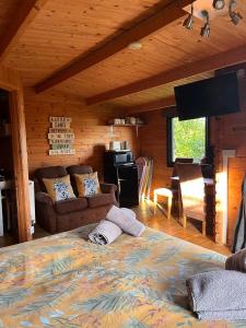 ein Wohnzimmer mit einem großen Bett in einer Hütte in der Unterkunft Morlais Log Cabin in Lyme Regis