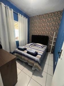 - une chambre avec un lit aux murs bleus dans l'établissement Casa para temporada super confortável 6km praia do forte Cabo Frio, à Cabo Frio