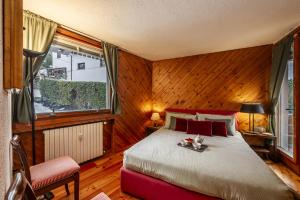 een slaapkamer met een bed in een kamer met een raam bij Maison Simone - wifi parking and mountain view in Courmayeur