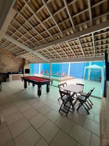 a room with a ping pong table and two chairs at Casa para temporada super confortável 6km praia do forte Cabo Frio in Cabo Frio