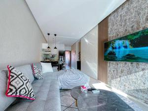 - un salon avec un canapé et une table en verre dans l'établissement New apartement next carre eden, à Marrakech