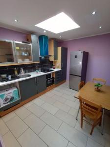 a large kitchen with a table and a refrigerator at Central and Quiet House in Charleroi in Charleroi