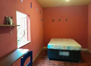 ein Zimmer mit einem Bett in der Ecke eines Zimmers in der Unterkunft Quarto na floresta com saída no igarapé - Espaço Caminho das pedras in Alter do Chao
