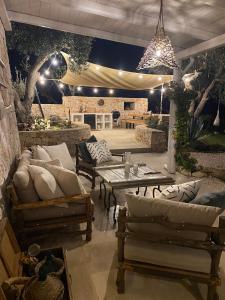 een patio met banken, een tafel en verlichting bij TRULLI TERRA DI MEZZO in Cisternino