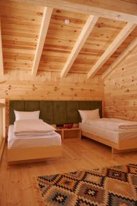 two beds in a room with wooden ceilings at MOKHY Chalet & Nature in Vorokhta