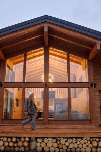 a person walking in front of a large glass window at MOKHY Chalet & Nature in Vorokhta