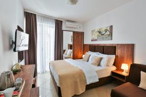 a hotel room with a large bed and a desk at Hotel La mer in Budva