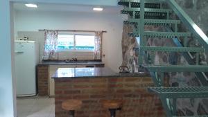 een keuken met een groene trap en een koelkast bij El Rinconcito de la Selva in La Calera