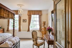 a bedroom with a bed and a desk and a desk at Saltcote Place in Rye
