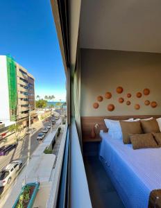a bedroom with a bed and a view of a street at Edf. Mar dos corais - a poucos passos do mar in Maceió