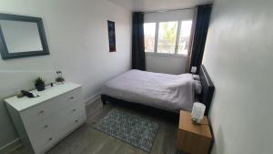 um pequeno quarto com uma cama e uma janela em Charmant et Spacieux Appartement em Le Pré-Saint-Gervais
