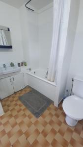 a bathroom with a toilet and a tub and a sink at Charmant et Spacieux Appartement in Le Pré-Saint-Gervais