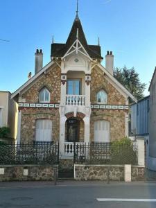 una gran casa de piedra con una torreta en una calle en Villa rustique,saint-Joseph Enghien, en Enghien-les-Bains