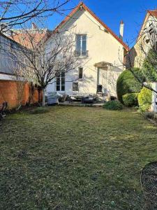 una gran casa blanca con un patio delante en Villa rustique,saint-Joseph Enghien, en Enghien-les-Bains