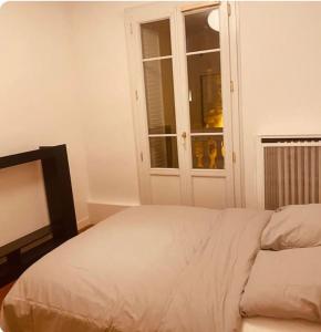 1 dormitorio con cama y ventana en Villa rustique,saint-Joseph Enghien, en Enghien-les-Bains