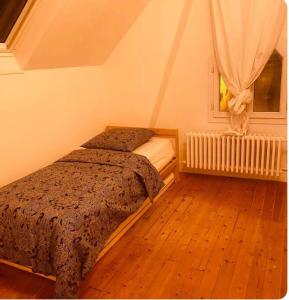 1 dormitorio con cama y ventana en Villa rustique,saint-Joseph Enghien, en Enghien-les-Bains