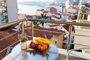 a plate of fruit on a table on a balcony at Hotel La mer in Budva
