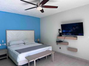 a bedroom with a large bed and a ceiling fan at Casa Mana: Beachfront Home w/pool on Playa Blanca in Zihuatanejo
