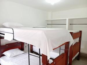 a bed with a white sheet on top of it at Apartamento central en Cali, Colombia 302 in Cali