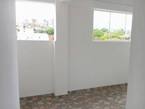 2 Fenster in einem Zimmer mit Fliesenboden in der Unterkunft Apartamento central en Cali, Colombia 302 in Cali