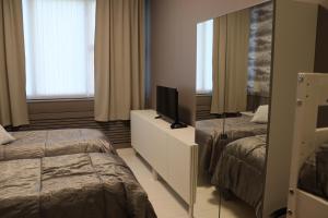 um quarto de hotel com duas camas e um espelho em GuestHouse Ikimetsä em Kuusamo