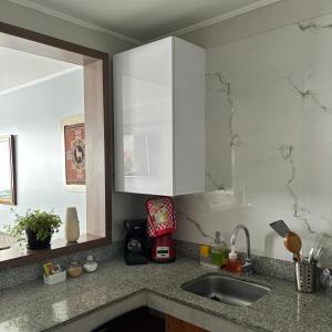 a kitchen with white cabinets and a sink at Departamento en Miraflores con Surquillo in Lima
