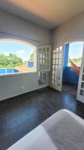 um quarto com duas janelas grandes e vista para o oceano em Pousada Genesis Guaruja no Guarujá