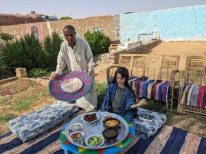 a man and a woman standing next to a table of food at بيت شمس in Aswan