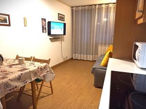 ein kleines Wohnzimmer mit einem Tisch und einem Sofa in der Unterkunft Fagus Cervinia apartment Vda Vacanze in Vetta CIR 0206 in Breuil-Cervinia