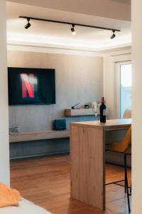 Habitación con TV y mesa con copa de vino. en Depto Marinas - Full Rent en Ushuaia