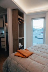 een slaapkamer met een groot bed en een groot raam bij Depto Marinas - Full Rent in Ushuaia