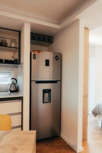 een keuken met een roestvrijstalen koelkast in een kamer bij Depto Marinas - Full Rent in Ushuaia
