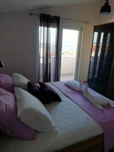 1 dormitorio con 1 cama grande con almohadas y ventana en Albatros, en Kaštel Sućurac