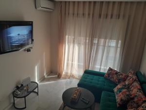 sala de estar con sofá verde y TV en Derb Omar,Tram (L1,L2,L3),Parking and wifi gratuit en Casablanca