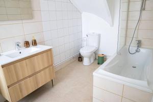 Un baño con lavabo, inodoro y bañera. en Gîte Les Camélias 2 chambres, 2 salles de bains, en Villers-Cotterêts