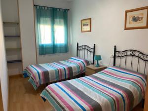 a bedroom with two beds and a window at El Mirador de Ines in El Puerto de Santa María