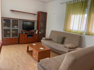 a living room with a couch and a tv at El Mirador de Ines in El Puerto de Santa María