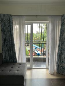 - un salon avec un canapé et une grande fenêtre dans l'établissement Furnished 2 Bedroom Apartment in Lavington Nairobi, à Nairobi