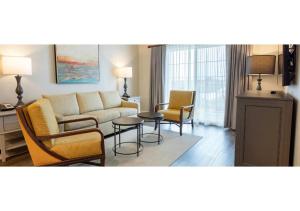 ein Wohnzimmer mit einem Sofa, Stühlen und einem Tisch in der Unterkunft Special Offer! Deluxe 2BR Condo Near Orlando Theme Parks - Disney World - Universal - SeaWorld - Space Center in Orlando