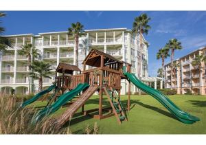 einen Spielplatz mit Rutsche in einem Park mit einem Gebäude in der Unterkunft Special Offer! Deluxe 2BR Condo Near Orlando Theme Parks - Disney World - Universal - SeaWorld - Space Center in Orlando