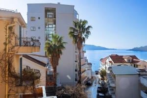 Blick auf eine Stadt mit Palmen und Wasser in der Unterkunft Hotel La mer in Budva