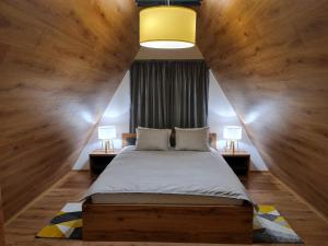 a bedroom with a large bed with wooden walls at Bajkoviti bungalov in Pale