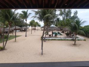 uma vista para uma praia com palmeiras e um resort em Pousada Recanto da Praia em São Miguel do Gostoso