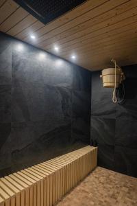 Cette chambre dispose d'une douche avec un seau sur le mur. dans l'établissement Le Nature - Sauna - Balnéo - Sparoom Sarreguemines, à Sarreguemines