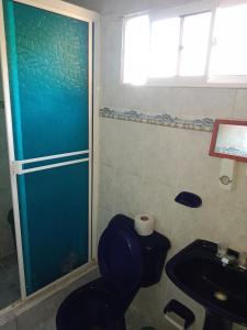 a bathroom with a toilet and a shower and a sink at Alojamiento Casa Luz Cielo in Puerto Colombia