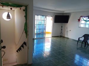 a room with a television and a tiled floor at Alojamiento Casa Luz Cielo in Puerto Colombia