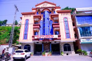 um edifício com um carro estacionado em frente em Mir Continental Hotel & Restaurant em Muzaffarabad