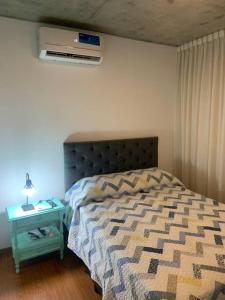 1 dormitorio con cama y mesita de noche con cama sidx sidx en Golf en Rosario